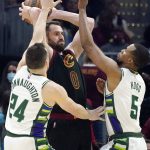 
              Cleveland Cavaliers' Kevin Love, center, passes as Milwaukee Bucks' Pat Connaughton, left, and Rodney Hood defend in the first half of an NBA basketball game, Wednesday, Jan. 26, 2022, in Cleveland. (AP Photo/Tony Dejak)
            