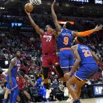 
              Miami Heat forward Jimmy Butler (22) shoots over New York Knicks guard RJ Barrett (9) during the second half of an NBA basketball game, Wednesday, Jan. 26, 2022, in Miami. The Heat won 110-96. (AP Photo/Lynne Sladky)
            