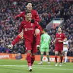
              Liverpool's Takumi Minamino, top, celebrates with Liverpool's Roberto Firmino after scoring his side's third goal during an English Premier League soccer match between Liverpool and Brentford at Anfield in Liverpool, England, Sunday, Jan. 16, 2022. (AP Photo/Jon Super)
            
