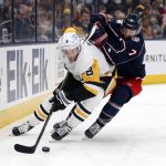 
              Pittsburgh Penguins defenseman Brian Dumoulin, left, controls the puck in front of Columbus Blue Jackets forward Sean Kuraly during the second period of an NHL hockey game in Columbus, Ohio, Friday, Jan. 21, 2022. (AP Photo/Paul Vernon)
            
