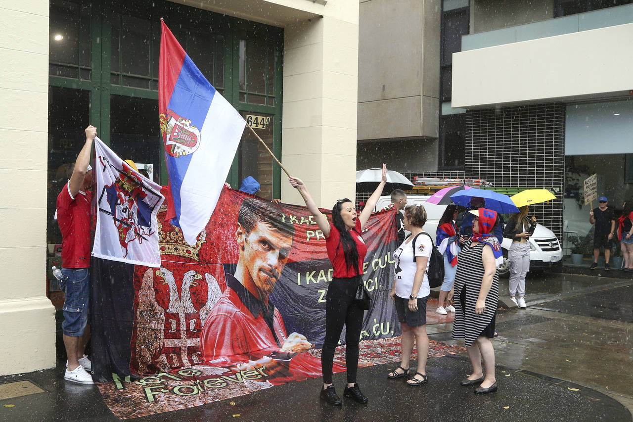 Protestors gather outside an immigration detention hotel where Serbia's Novak Djokovic is believed ...