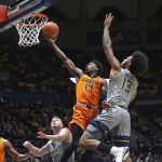 
              Oklahoma State guard Bryce Williams (14) shoots while defended by West Virginia forward Isaiah Cottrell (13) during the first half of an NCAA college basketball game in Morgantown, W.Va., Tuesday, Jan. 11, 2022. (AP Photo/Kathleen Batten)
            