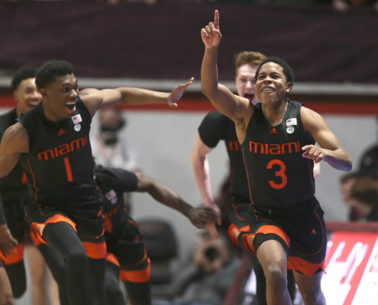 Miami's Charlie Moore (3) right, celebrates with Anthony Walker (1) left, and Sam Waardenburg (21) ...