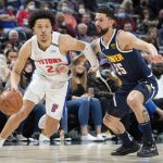 
              Detroit Pistons guard Cade Cunningham, left, drives past Denver Nuggets guard Austin Rivers in the first half of an NBA basketball game Sunday, Jan. 23, 2022, in Denver. (AP Photo/David Zalubowski)
            