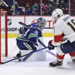 
              Vancouver Canucks goalie Spencer Martin (30) watches as the puck deflects wide of the goal off the stick of Florida Panthers' Aleksander Barkov (16) during overtime in an NHL hockey game Friday, Jan. 21, 2022, in Vancouver, British Columbia. (Darryl Dyck/The Canadian Press via AP)
            
