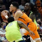 
              Phoenix Suns guard Devin Booker is pressured by Minnesota Timberwolves guard Malik Beasley (5) during the first half of an NBA basketball game, Friday, Jan. 28, 2022, in Phoenix. (AP Photo/Matt York)
            