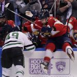
              Florida Panthers defenseman Aaron Ekblad (5) attempts to slam Dallas Stars center Rhett Gardner (49) into the boards during the first period of an NHL hockey game, Friday, Jan. 14, 2022, in Sunrise, Fla. (AP Photo/Wilfredo Lee)
            