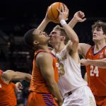 
              Notre Dame's Dane Goodwin, second from right, tries to drive between Clemson's David Collins (13), Nick Honor and PJ Hall (24) during the first half of an NCAA college basketball game Wednesday, Jan. 12, 2022, in South Bend, Ind. (AP Photo/Robert Franklin)
            