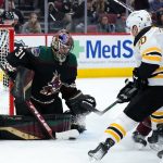 
              Arizona Coyotes goaltender Scott Wedgewood (31) makes a save on a shot by Boston Bruins center Curtis Lazar (20) as Coyotes left wing Antoine Roussel (26) defends during the second period of an NHL hockey game Friday, Jan. 28, 2022, in Glendale, Ariz. (AP Photo/Ross D. Franklin)
            
