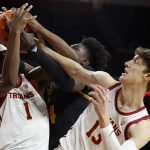 
              Southern California forward Chevez Goodwin, left, and guard Drew Peterson, right, vie for the ball against Arizona State center Enoch Boakye, center, during the first half of an NCAA college basketball game in Los Angeles, Monday, Jan. 24, 2022. (AP Photo/Alex Gallardo)
            