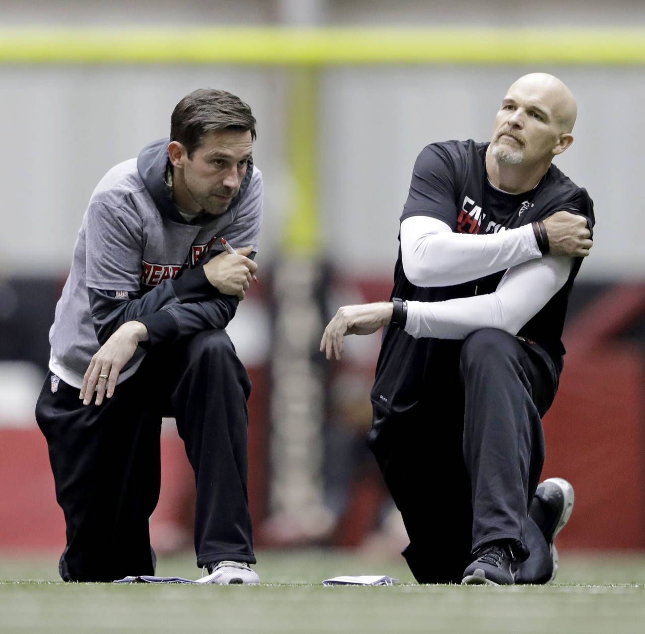 FILE - Atlanta Falcons head coach Dan Quinn, right, talks with offensive coordinator Kyle Shanahan ...