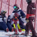 
              Team members console Mikaela Shiffrin, of the United States after she skied out in the first run of the women's slalom at the 2022 Winter Olympics, Wednesday, Feb. 9, 2022, in the Yanqing district of Beijing. (AP Photo/Robert F. Bukaty)
            