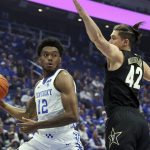 
              Kentucky's Keion Brooks Jr. (12) prepares to pass the ball as Vanderbilt's Quentin Millora-Brown (42) defends during the first half of an NCAA college basketball game in Lexington, Ky., Wednesday, Feb. 2, 2022. (AP Photo/James Crisp)
            