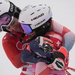 
              Michelle Gisin, of Switzerland, embraces teammate Wendy Holdener, after finishing the women's combined slalom at the 2022 Winter Olympics, Thursday, Feb. 17, 2022, in the Yanqing district of Beijing. (AP Photo/Luca Bruno)
            