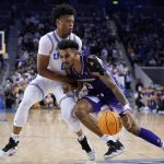 Washington guard Jamal Bey (5) is defended by UCLA guard Jaylen Clark during the first half of an NCAA college basketball game Saturday, Feb. 19, 2022, in Los Angeles. (AP Photo/Marcio Jose Sanchez)