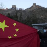 
              A visitor holds the Chinese flag near the Badaling section of the Great Wall of China on the outskirts of Beijing, China, on Feb. 8, 2022. China has thousands of years of doing things in a really big way, reinforcing its perceived place in the world and the political power of its leaders — from emperors to Mao Zedong to Xi Jinping. None of this bigness is new. It goes back to a dozen dynasties that ruled China for thousands of years, a tradition of projecting power that was adopted by the Chinese Communist Party when it came to power in 1949. It could be termed simply: big, bigger and biggest — and then some. (AP Photo/Ng Han Guan)
            