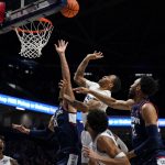 
              Xavier guard Dwon Odom, top, shoots over Connecticut's Tyrese Martin (4) during the first half of an NCAA college basketball game Friday, Feb. 11, 2022, in Cincinnati. (AP Photo/Jeff Dean)
            
