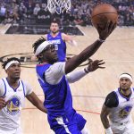 
              Los Angeles Clippers guard Reggie Jackson, center, shoots as Golden State Warriors center Kevon Looney, left, and guard Gary Payton II defend during the first half of an NBA basketball game Monday, Feb. 14, 2022, in Los Angeles. (AP Photo/Mark J. Terrill)
            