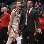 
              Connecticut's Paige Bueckers, left, reacts after making her first basket after coming back from being injured, in the first half of an NCAA college basketball game against St. John's, Friday, Feb. 25, 2022, in Hartford, Conn. (AP Photo/Jessica Hill)
            