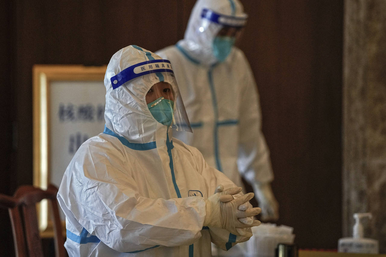 Medical workers wearing protective gear prepares swabs for people taking part in the Beijing Winter...