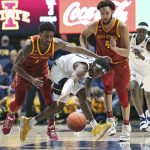 
              West Virginia guard Malik Curry (10), Iowa State guard Izaiah Brockington (1) and forward George Conditt IV (4) go for a loose ball during the second half of an NCAA college basketball game in Morgantown, W.Va., Tuesday, Feb. 8, 2022. (AP Photo/Kathleen Batten)
            