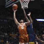 
              Texas forward Timmy Allen (0) shoots while defended by West Virginia forwards Jalen Bridges, center, and Isaiah Cottrell, right, during the first half of an NCAA college basketball game in Morgantown, W.Va., Saturday, Feb. 26, 2022. (AP Photo/Kathleen Batten)
            
