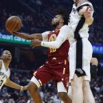 
              Cleveland Cavaliers' Darius Garland (10) puts up a shot against San Antonio Spurs' Jakob Poeltl (25) during the first half of an NBA basketball game, Wednesday, Feb. 9, 2022, in Cleveland. The Cavaliers defeated the Spurs 105-92. (AP Photo/Ron Schwane)
            