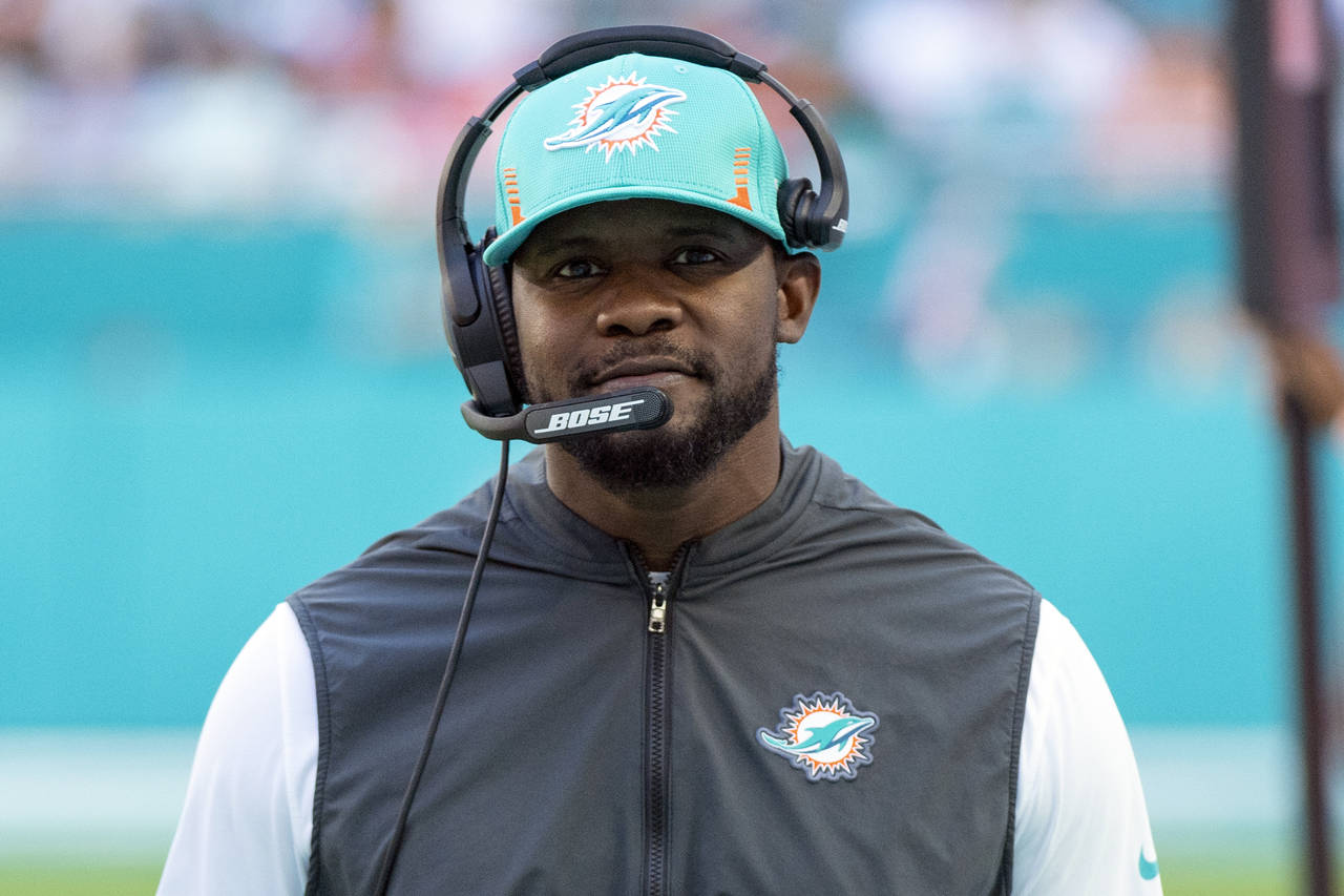 FILE - Miami Dolphins head coach Brian Flores smiles on the sidelines during an NFL football game a...