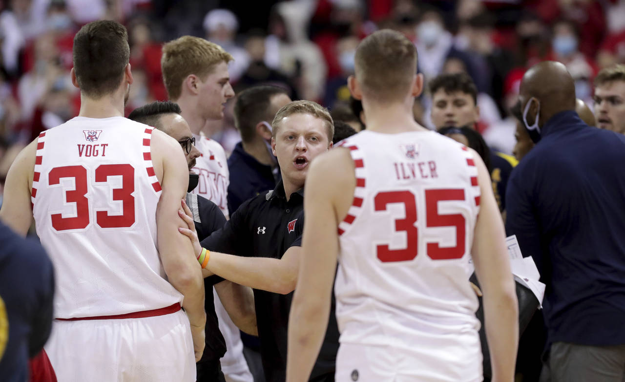 Wisconsin and Michigan players and coaches are involved in a scuffle with Michigan head coach Juwan...