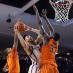 
              Oklahoma guard Jordan Goldwire (0) shoots between Oklahoma State guard Bryce Thompson, left, and forward Moussa Cisse (33) in overtime of an NCAA college basketball game Saturday, Feb. 26, 2022, in Norman, Okla. (AP Photo/Sue Ogrocki)
            