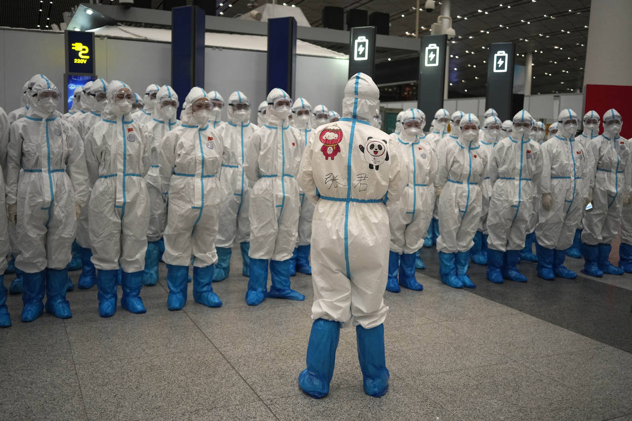 Olympic workers in protective clothing have a meeting at Beijing Capital International Airport afte...
