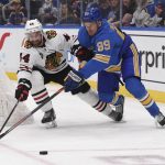 
              Chicago Blackhawks defenseman Calvin de Haan (44) and St. Louis Blues left wing Pavel Buchnevich (89) reach for the puck during the second period of an NHL hockey game Saturday, Feb. 12, 2022, in St. Louis. (AP Photo/Joe Puetz)
            