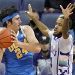 
              UCLA guard Jaime Jaquez Jr. (24) looks to pass around the defense of Washington guard PJ Fuller, right, during the first half of an NCAA college basketball game, Monday, Feb. 28, 2022, in Seattle. (AP Photo/Ted S. Warren)
            