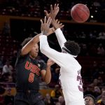 
              CORRECTS LOCATION TO TEMPE, INSTEAD OF PHOENIX - Southern California guard Boogie Ellis (0) dishes over Arizona State forward Alonzo Gaffney during the first half of an NCAA college basketball game, Thursday, Feb. 3, 2022, in Tempe, Ariz. (AP Photo/Matt York)
            