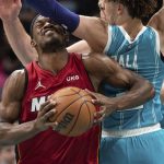 
              Charlotte Hornets guard LaMelo Ball (2) fouls Miami Heat forward Jimmy Butler (22) during the first half of an NBA basketball game in Charlotte, N.C., Saturday, Feb. 5, 2022. (AP Photo/Jacob Kupferman)
            