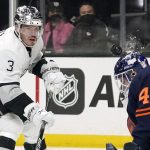 
              A shot by Los Angeles Kings defenseman Matt Roy, left, hits Edmonton Oilers goaltender Mike Smith in the helmet during the second period of an NHL hockey game Tuesday, Feb. 15, 2022, in Los Angeles. (AP Photo/Mark J. Terrill)
            