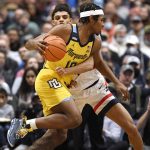 
              Marquette's Justin Lewis (10) is guarded by Connecticut's Andre Jackson in the first half of an NCAA college basketball game, Tuesday, Feb. 8, 2022, in Hartford, Conn. (AP Photo/Jessica Hill)
            