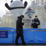 
              FILE - Security officers patrol near the edge of the closed-loop area on the Olympic Green near the main media center at the 2022 Winter Olympics in Beijing, Jan. 30, 2022. (AP Photo/Mark Schiefelbein, File)
            