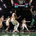 
              Boston Celtics' Jayson Tatum goes to shoot against Atlanta Hawks' Onyeka Okongwu (17) and De'Andre Hunter during the first quarter of an NBA basketball game Sunday, Feb. 13, 2022, in Boston. (AP Photo/Winslow Townson)
            