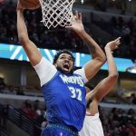 
              Minnesota Timberwolves center Karl-Anthony Towns (32) goes up for a dunk past Chicago Bulls center Tony Bradley during the first half of an NBA basketball game in Chicago, Friday, Feb. 11, 2022. (AP Photo/Nam Y. Huh)
            