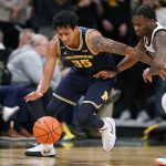 
              Michigan guard Eli Brooks (55) fights for a loose ball with Iowa guard Joe Toussaint, right, during the second half of an NCAA college basketball game, Thursday, Feb. 17, 2022, in Iowa City, Iowa. (AP Photo/Charlie Neibergall)
            