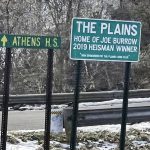 
              A roadside sign at the village limits of The Plains, Ohio, recognizes Joe Burrow as the winner of the 2019 Heisman Trophy, Wednesday, Feb. 9, 2022. Burrow grew up in the village near Athens, Ohio. The other sign points to where he played football at Athens High School. He'll be the quarterback for the Cincinnati Bengals, who are schedule to face the Los Angeles Rams in the NFL football Super Bowl on Sunday. (AP Photo/Mitch Stacy)
            