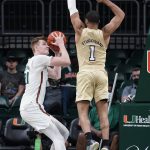 
              Miami forward Sam Waardenburg (21) looks for a shot as Georgia Tech guard Kyle Sturdivant (1) attempts to block during the first half of an NCAA college basketball game, Wednesday, Feb. 9, 2022, in Coral Gables, Fla. (AP Photo/Wilfredo Lee)
            