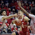 
              Wisconsin guard Brad Davison (34) gets a hand to the face from Rutgers guard Geo Baker, left, as he drives to the basket during the first half of an NCAA college basketball game Saturday, Feb. 26, 2022, in Piscataway, N.J. (AP Photo/Adam Hunger)
            