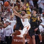 
              Texas forward Timmy Allen (0) reaches for a rebound against Baylor forward Jeremy Sochan, left, and guard Matthew Mayer (24) during the first half of an NCAA college basketball game Monday, Feb. 28, 2022, in Austin, Texas. (AP Photo/Eric Gay)
            