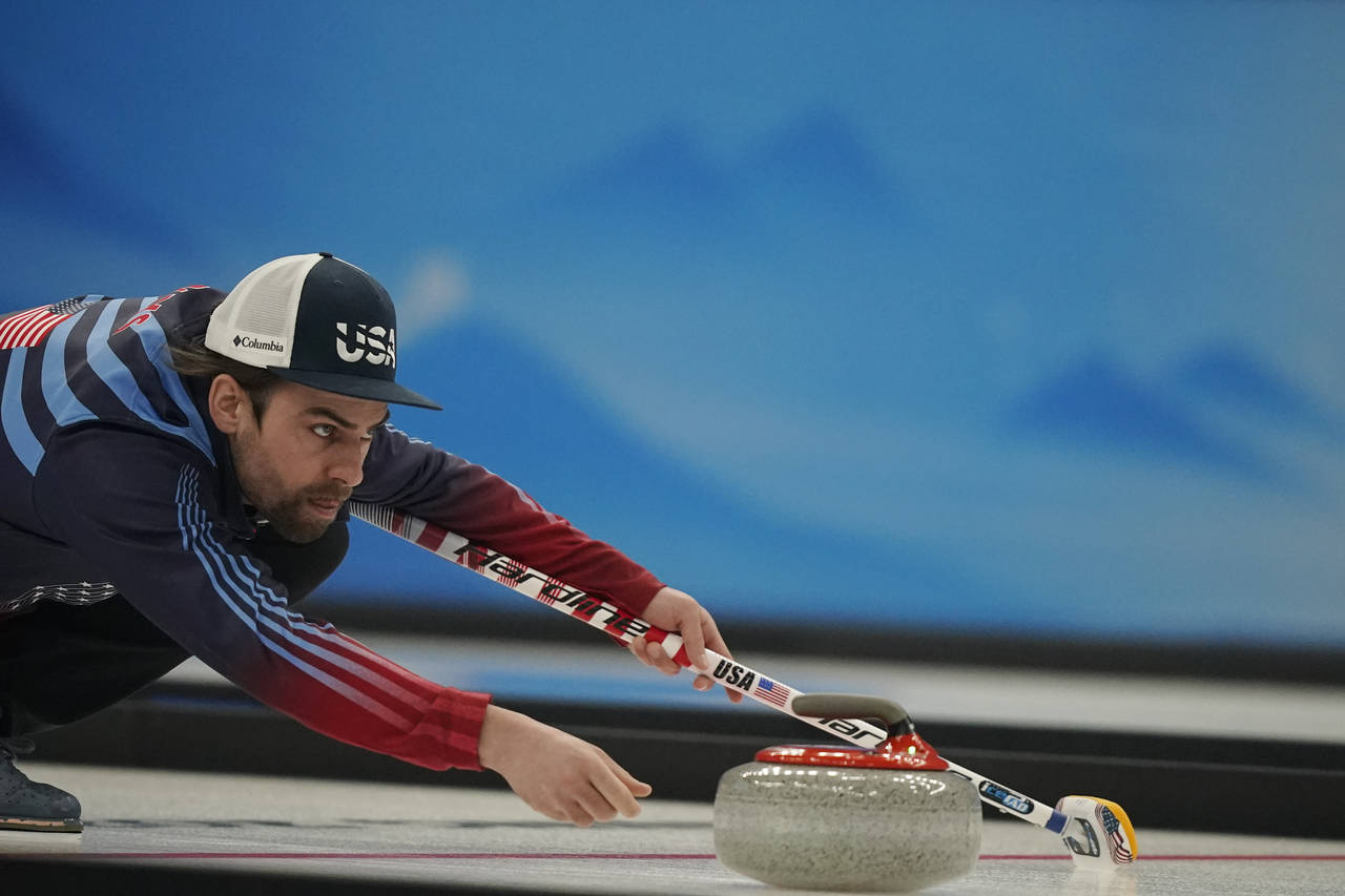 Christopher Plys, of the United States, throws a rock during the mixed doubles curling match agains...