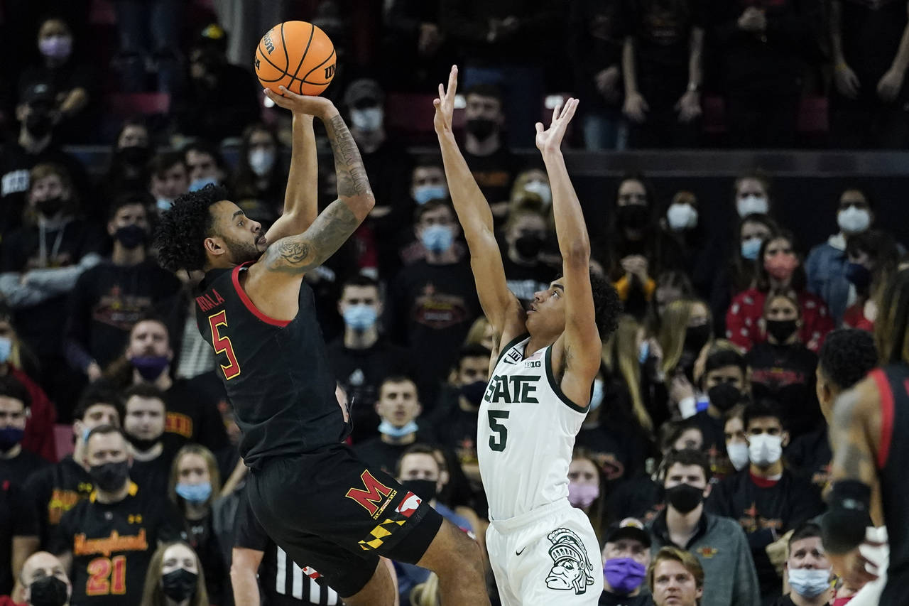 Maryland guard Eric Ayala, left, shoots against Michigan State guard Max Christie during the first ...