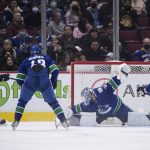 
              Vancouver Canucks goalie Thatcher Demko, second from right, stops Seattle Kraken's Morgan Geekie, left, during the second period of an NHL hockey game in Vancouver, British Columbia, Monday, Feb. 21, 2022. (Darryl Dyck/The Canadian Press via AP)
            