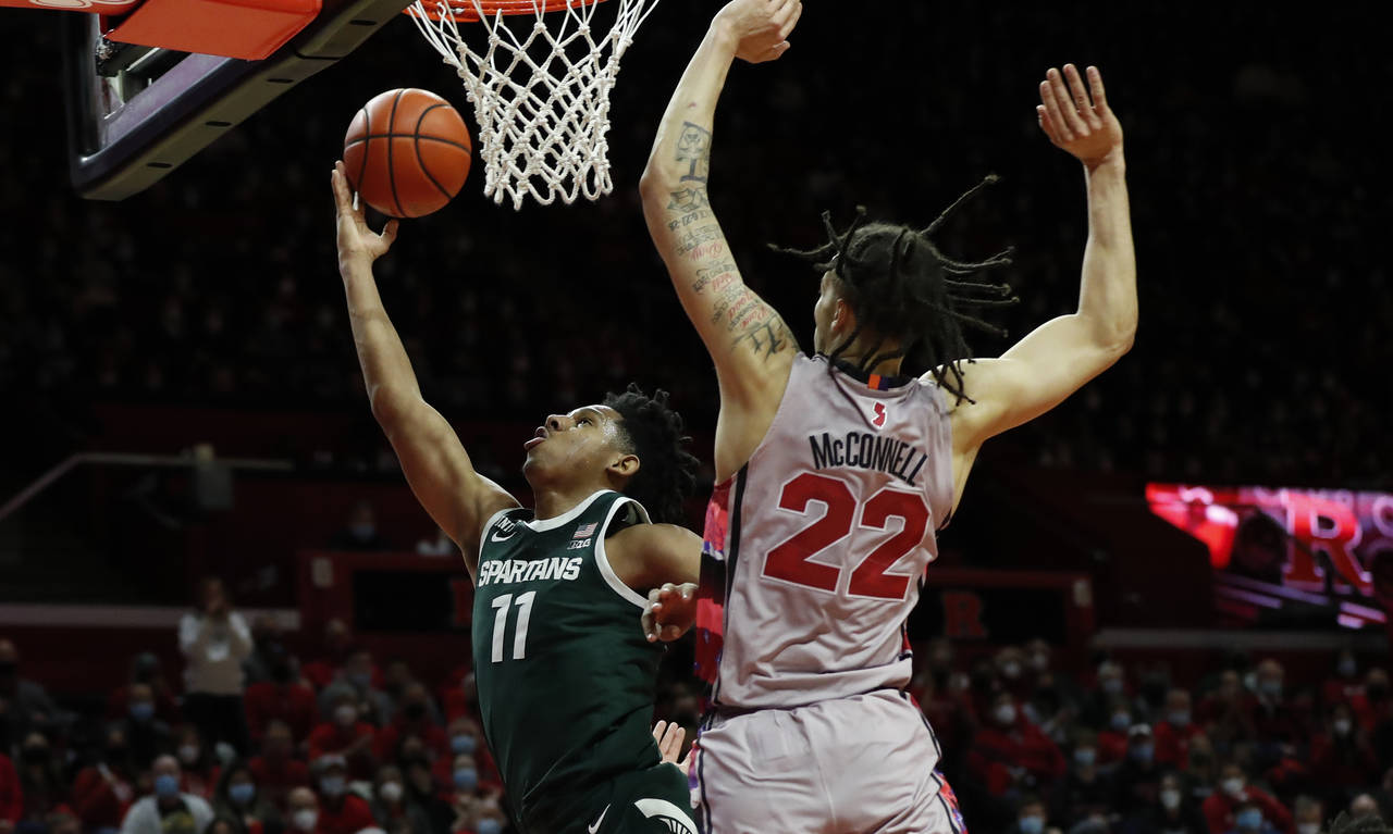 Michigan State guard A.J. Hoggard (11) drives to the basket against Rutgers guard Caleb McConnell (...
