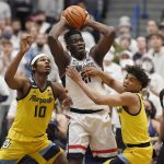 
              Connecticut's Adama Sanogo is pressured by Marquette's Justin Lewis, left, and Marquette's Stevie Mitchell, right, in the first half of an NCAA college basketball game, Tuesday, Feb. 8, 2022, in Hartford, Conn. (AP Photo/Jessica Hill)
            